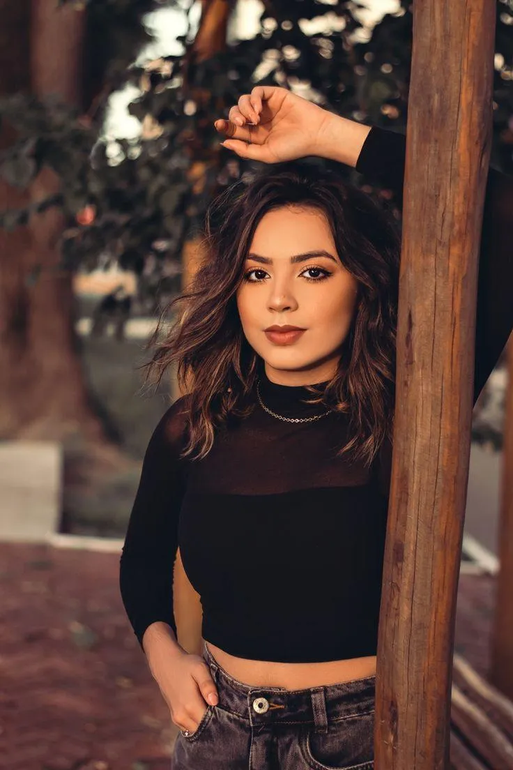 Woman Posing in a Black Outfit with a Natural Background