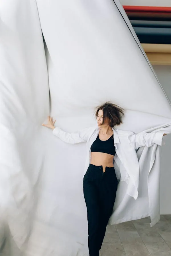 Woman Posing with Flowing White Fabric in a Bright Room