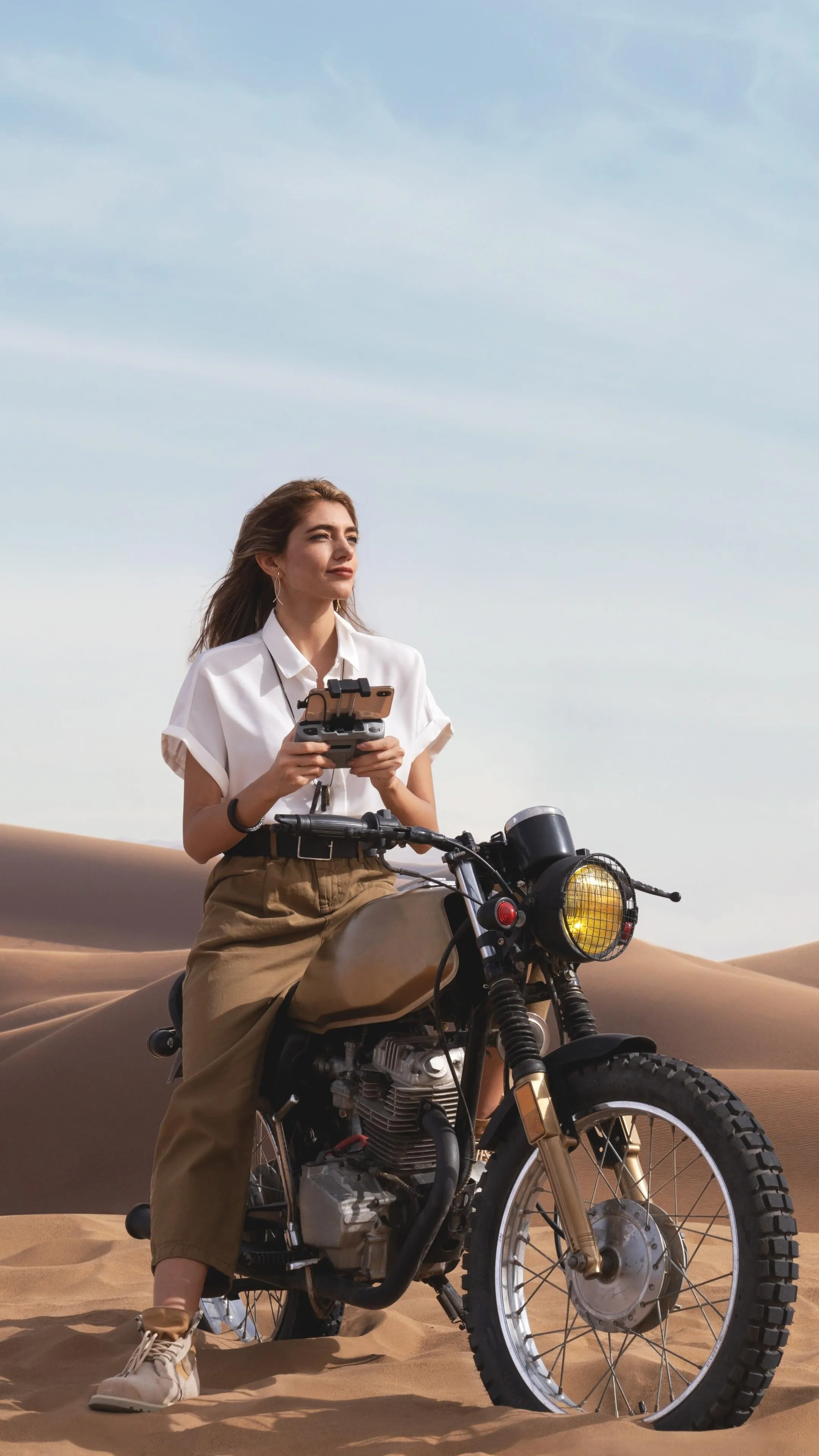 Woman Posing on a Motorbike in the Desert During Golden Hour