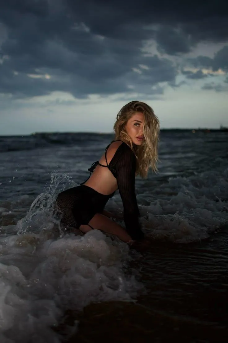 Woman Posing in the Sea with Waves Crashing Around Her Image