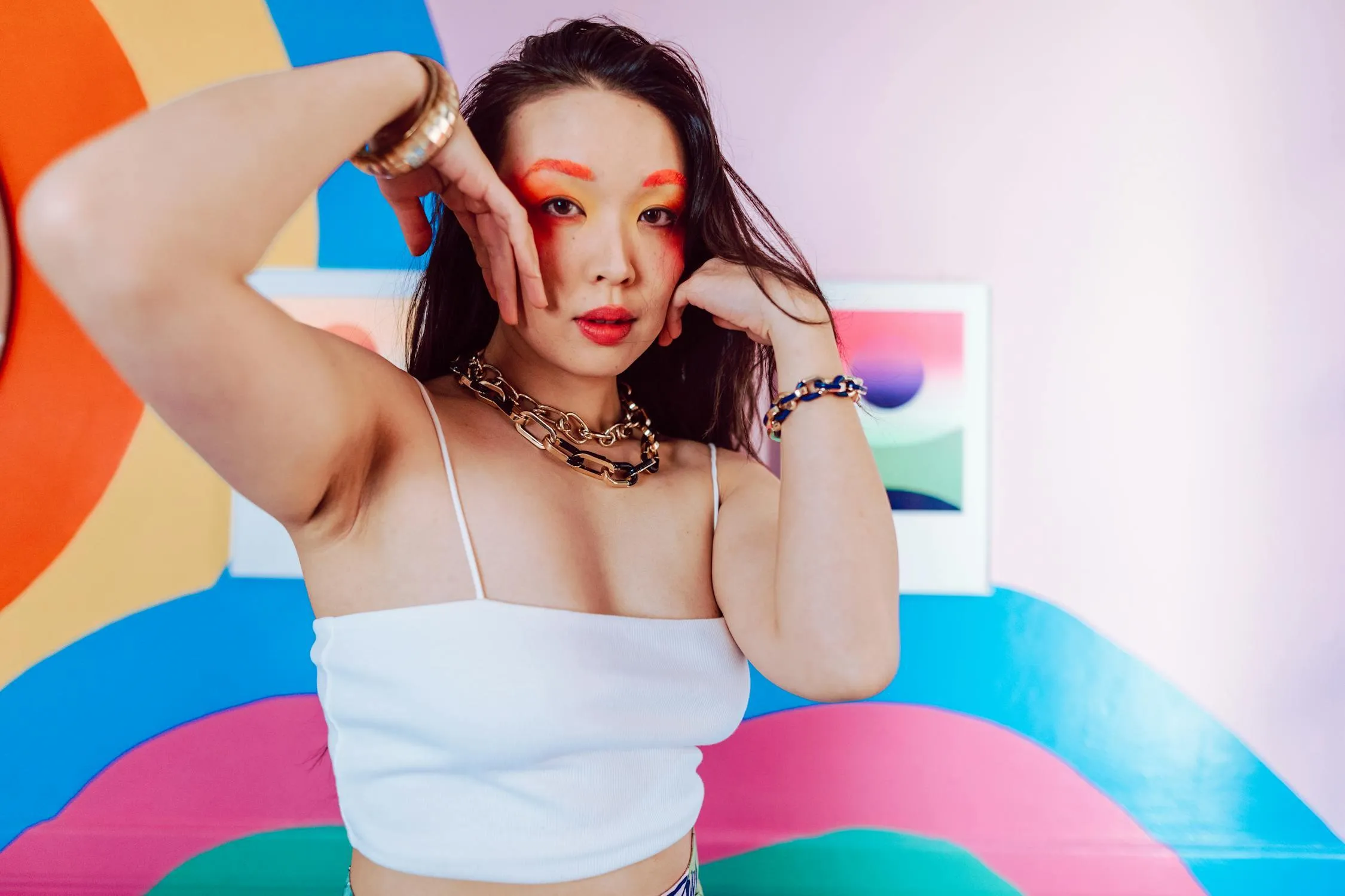 Woman Posing in a White Top Against Colorful Wall Background
