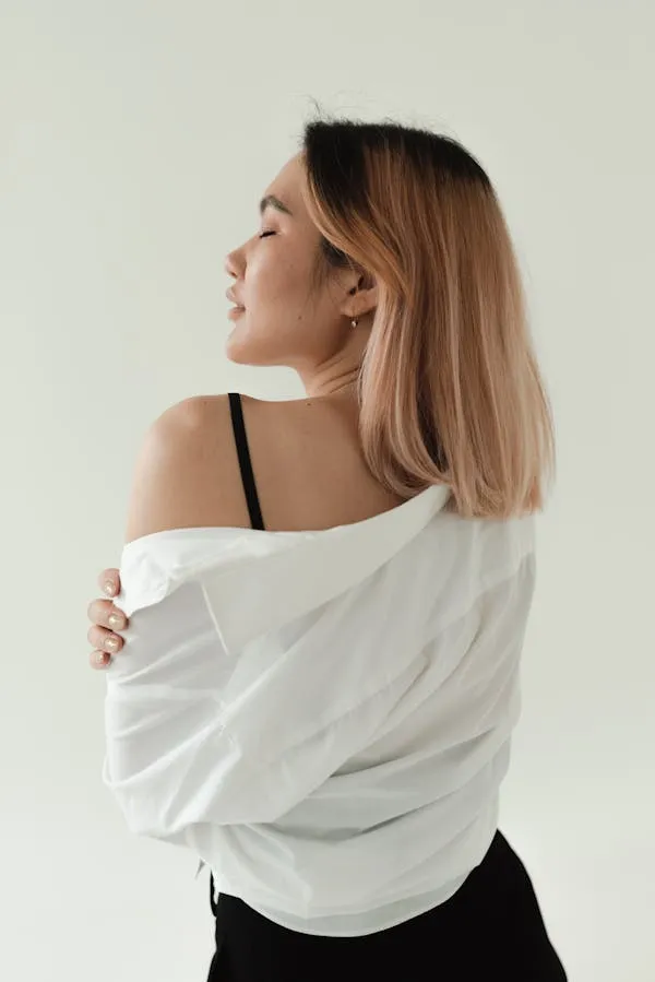Woman in Profile Wearing a White Off Shoulder Top Indoors