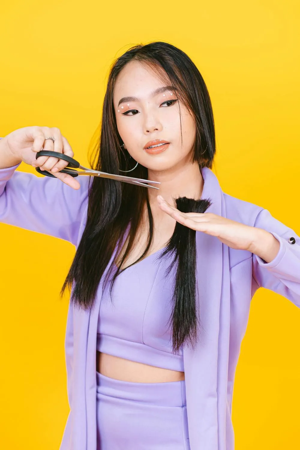 Woman in a Purple Outfit Posing Against a Bright Yellow Wall