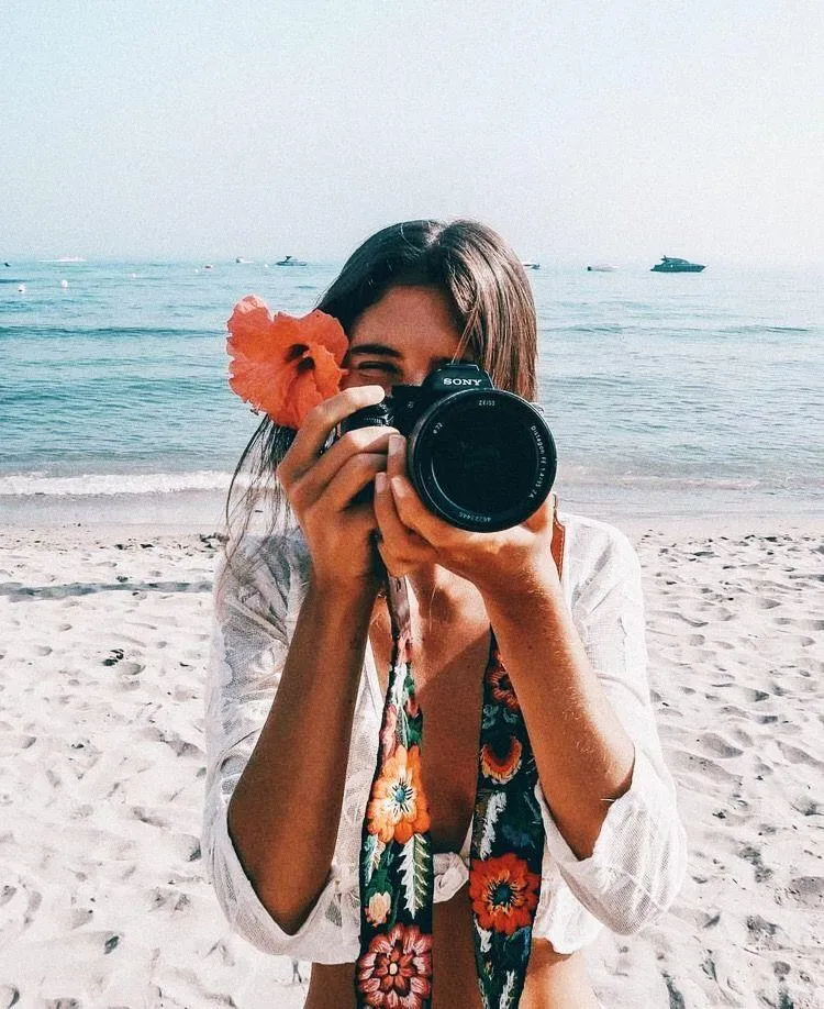 Woman in a Red Cloak Standing on Dock Over Calm Water Image