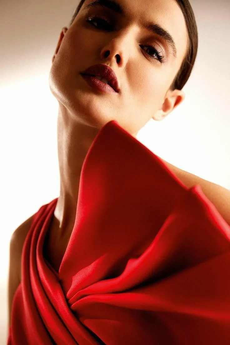Woman in Red Dress Looking Up with a Soft and Graceful Pose