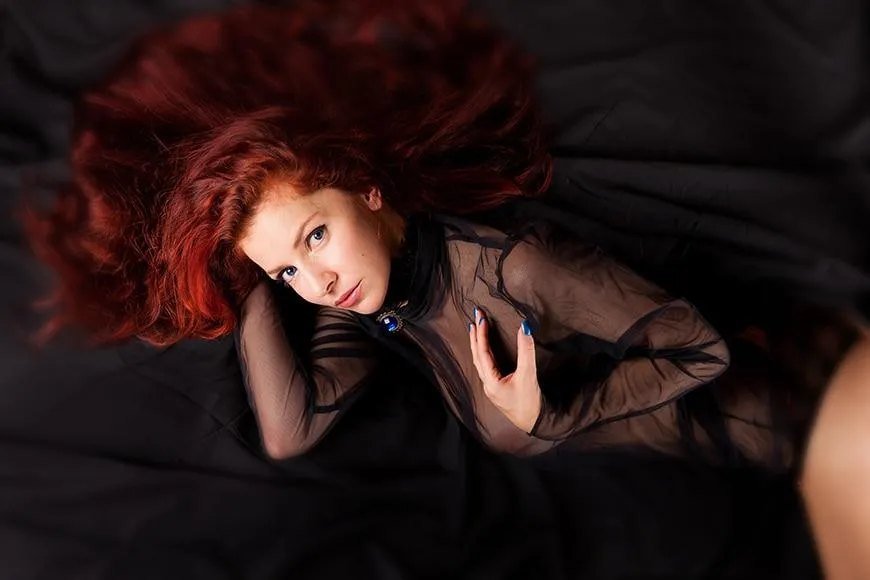 Woman with Red Hair Lying Down Wearing a Sheer Black Top