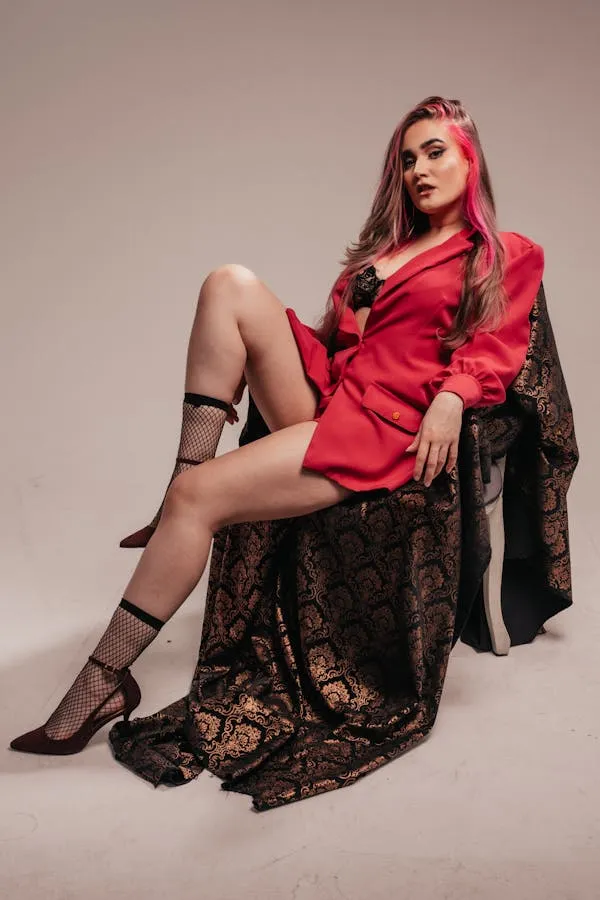 Woman in Red Jacket and Black Lace Skirt Seated on a Chair