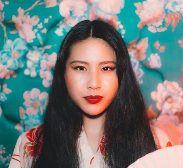 Woman with Red Lipstick Standing in Front of a Floral Wall