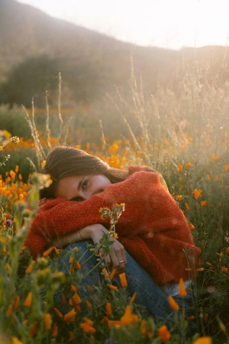 Woman in a Red Sweater Sitting in a Sunlit Meadow Field