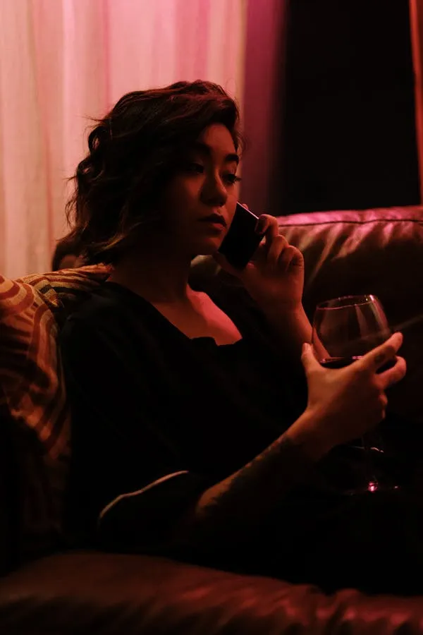 Woman Relaxing Indoors with Soft Red Lighting in the Evening