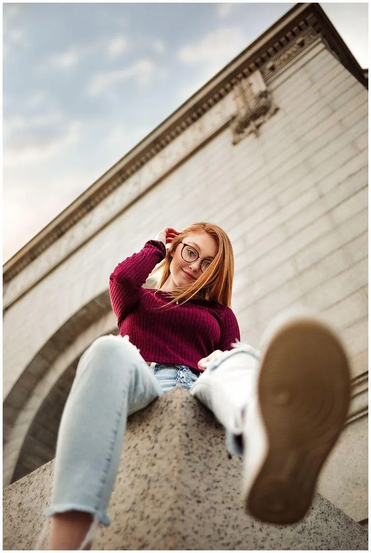 Woman Seated Near a Stone Wall in a Casual Autumn Outfit