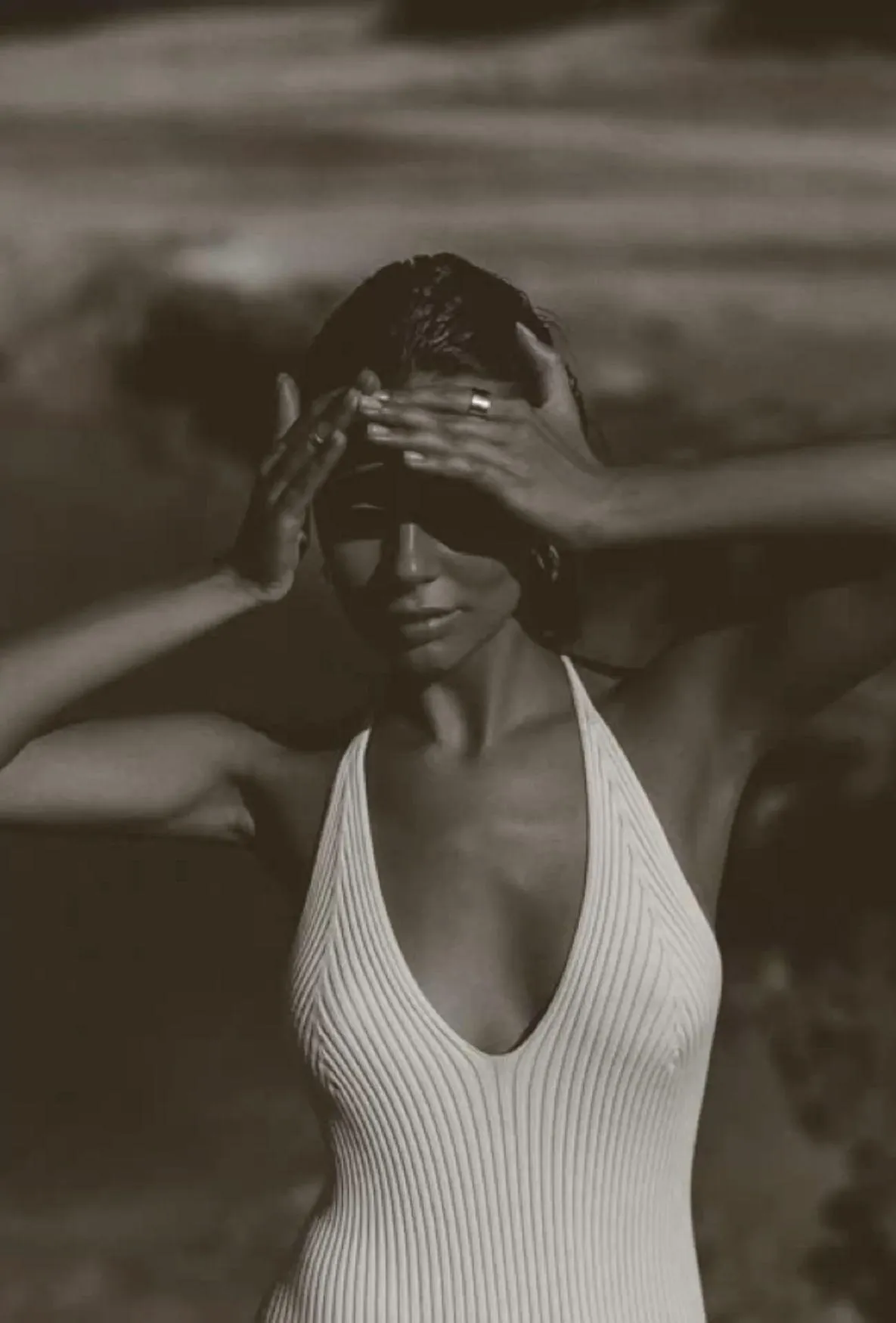 Woman Shielding Eyes From Sunlight Standing Near the Ocean