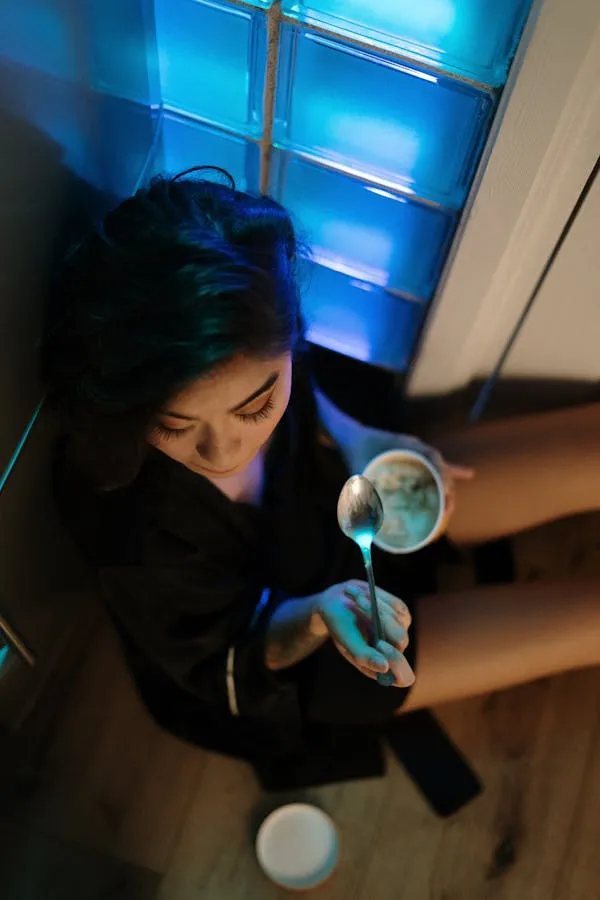 Woman Sipping Drink Under Moody Blue Lighting Free Wallpaper