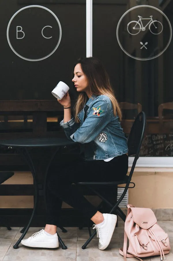 Woman Sitting At a Coffee Shop Enjoying a Peaceful Moment