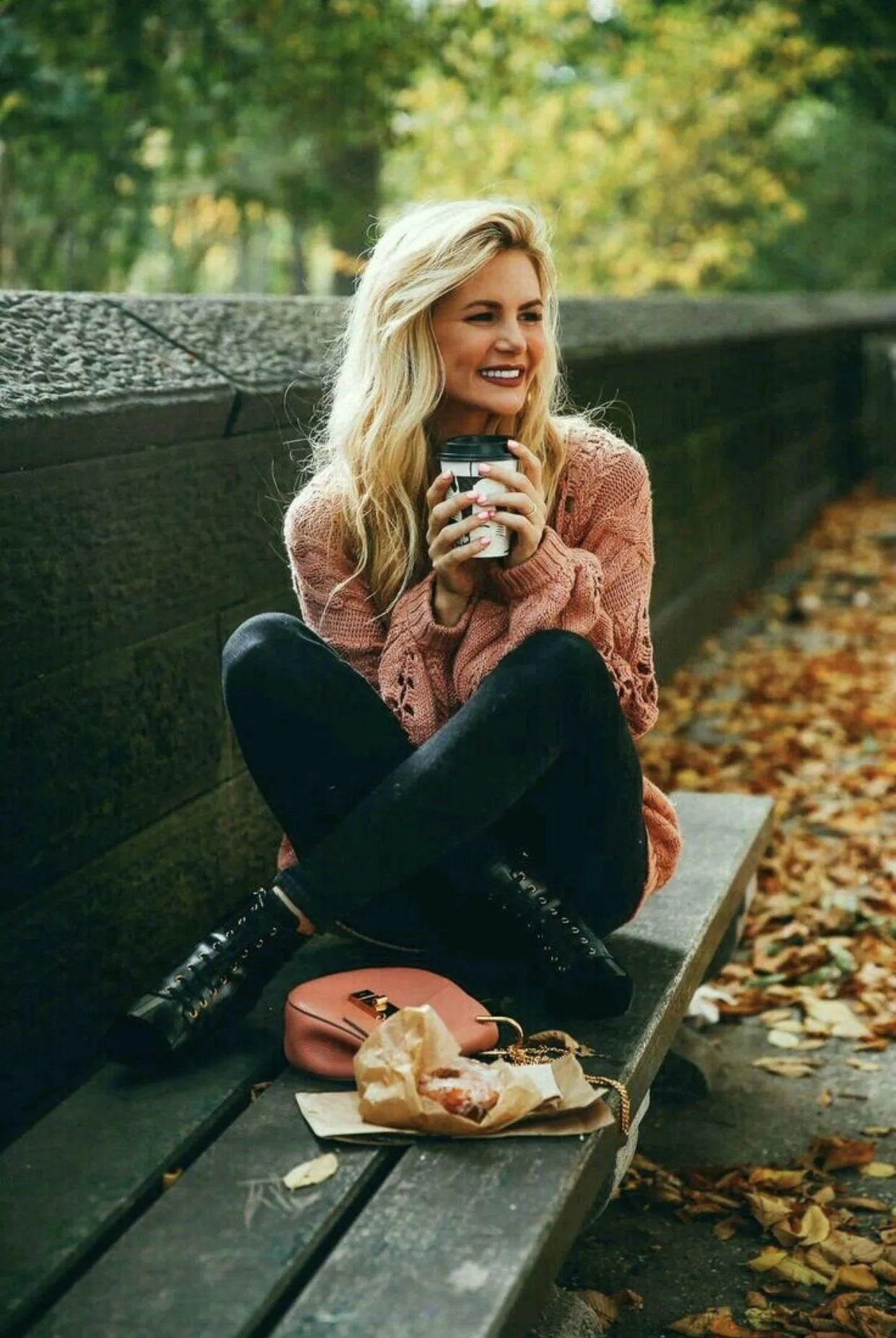 Woman Sitting on a Bench Enjoying Coffee in an Autumn Park