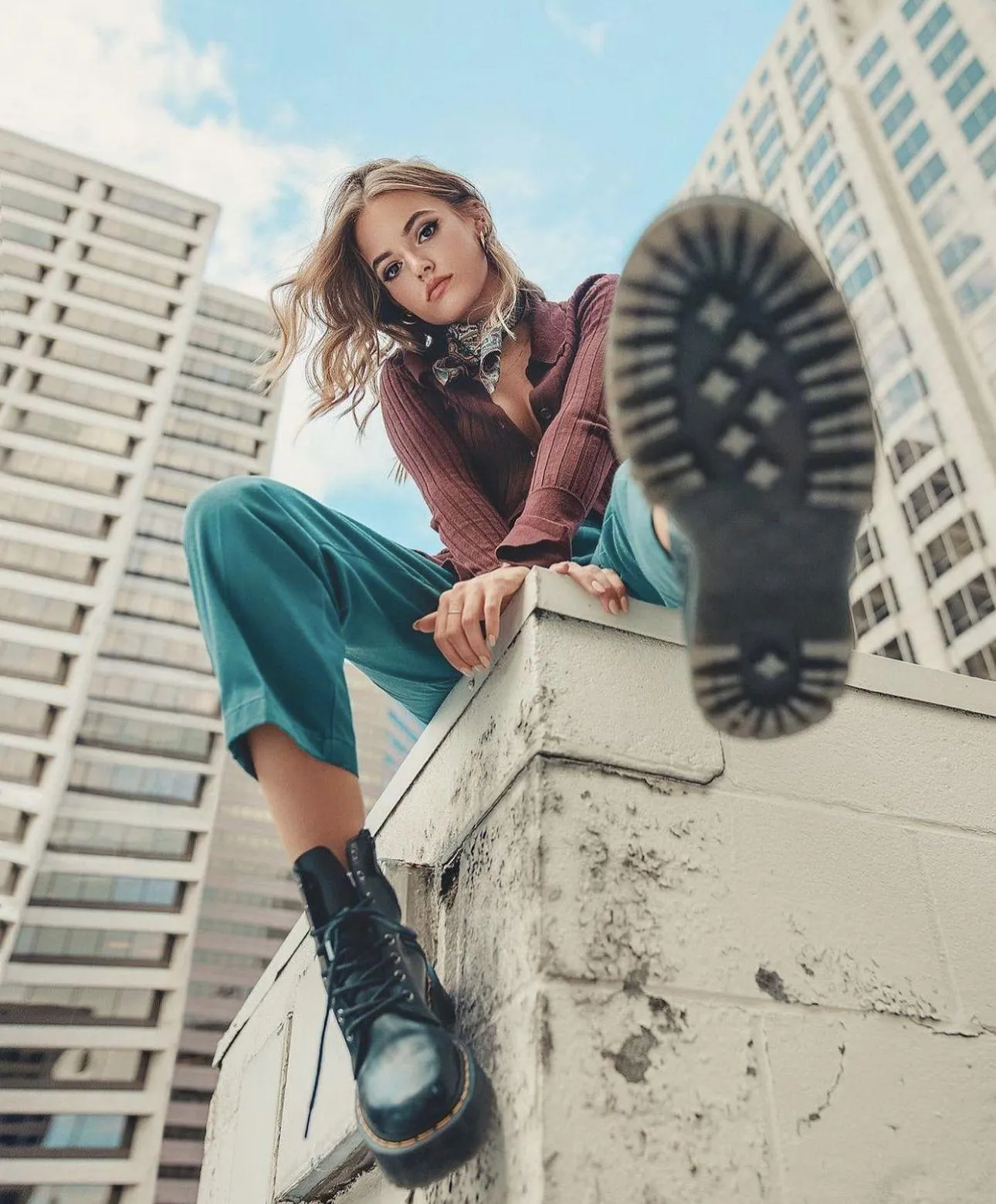 Woman Sitting Casually on the Rooftop Stairs in Green Pants