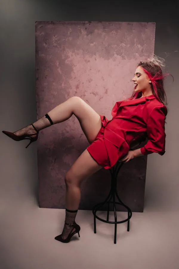 Woman Sitting on a Chair in a Red Dress with a Confidence
