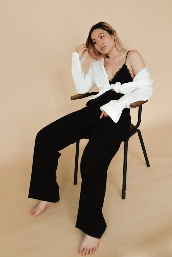 Woman Sitting Confidently in Black Outfit with Natural Pose