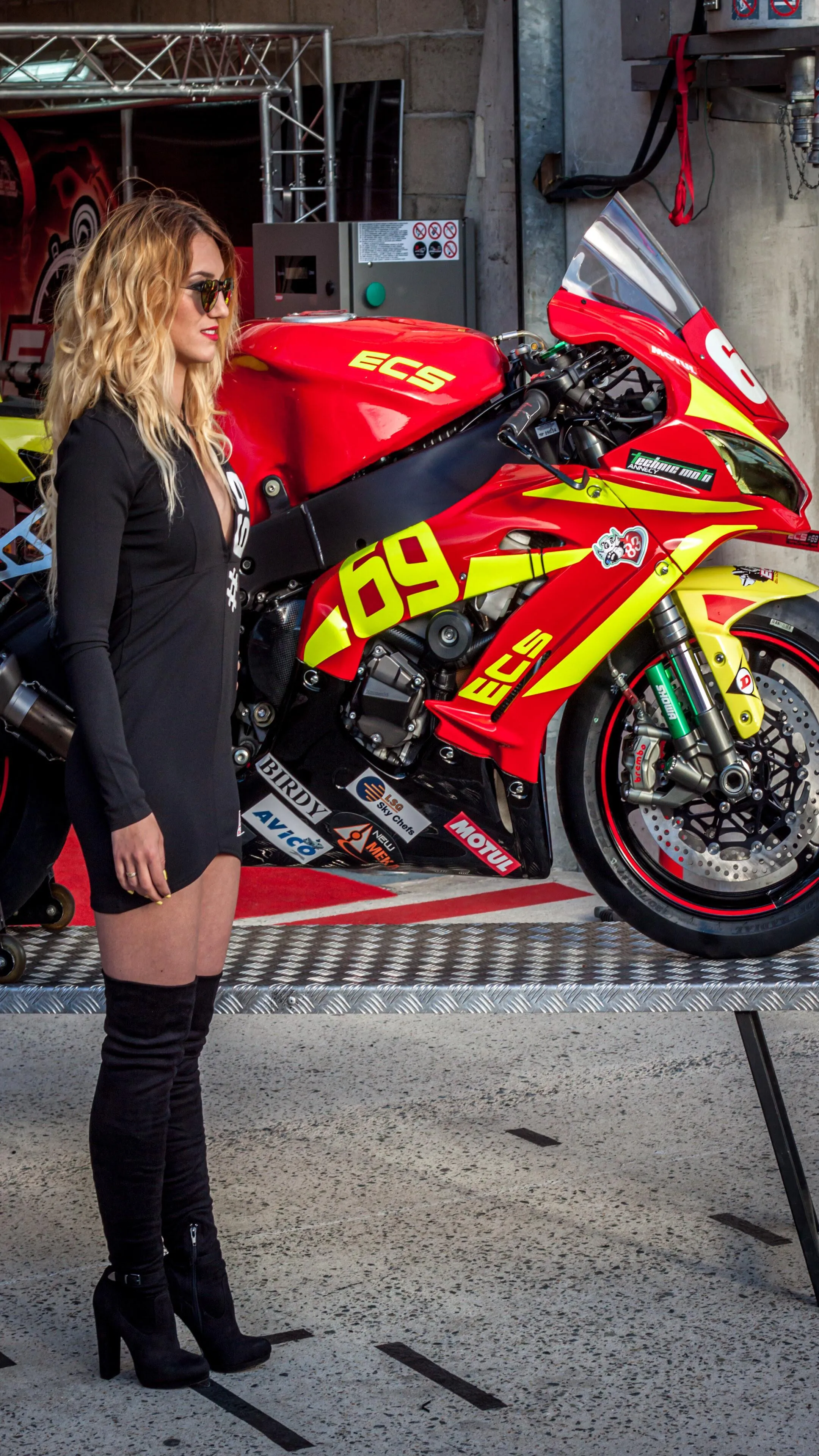 Woman Sitting on a Custom Motorcycle in a Bright Workshop