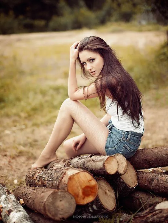 Woman Sitting in a Dry Field Smiling with Her Eyes Closed
