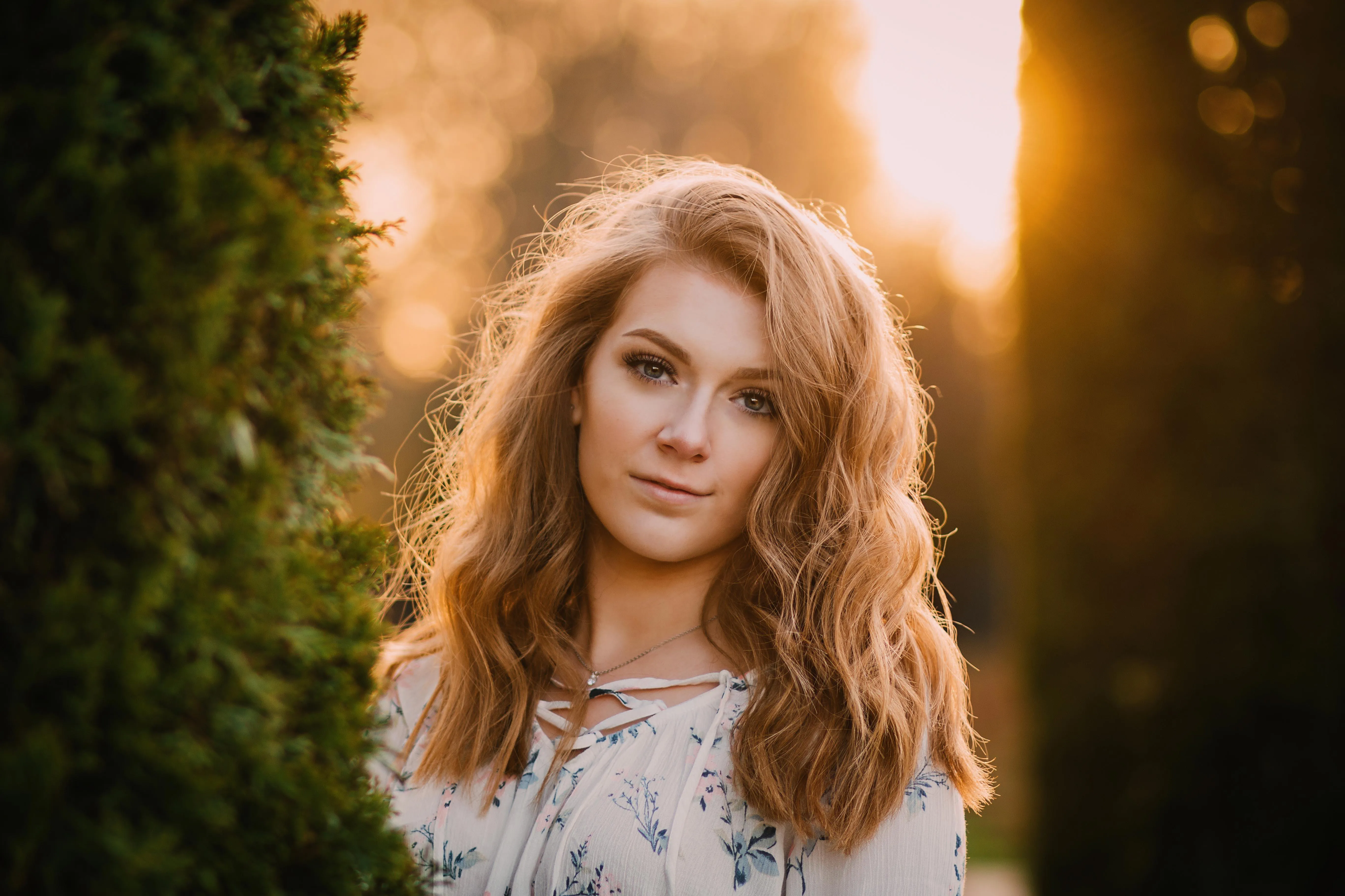 Woman Sitting on a Motorcycle Surrounded by Dry Tall Grass