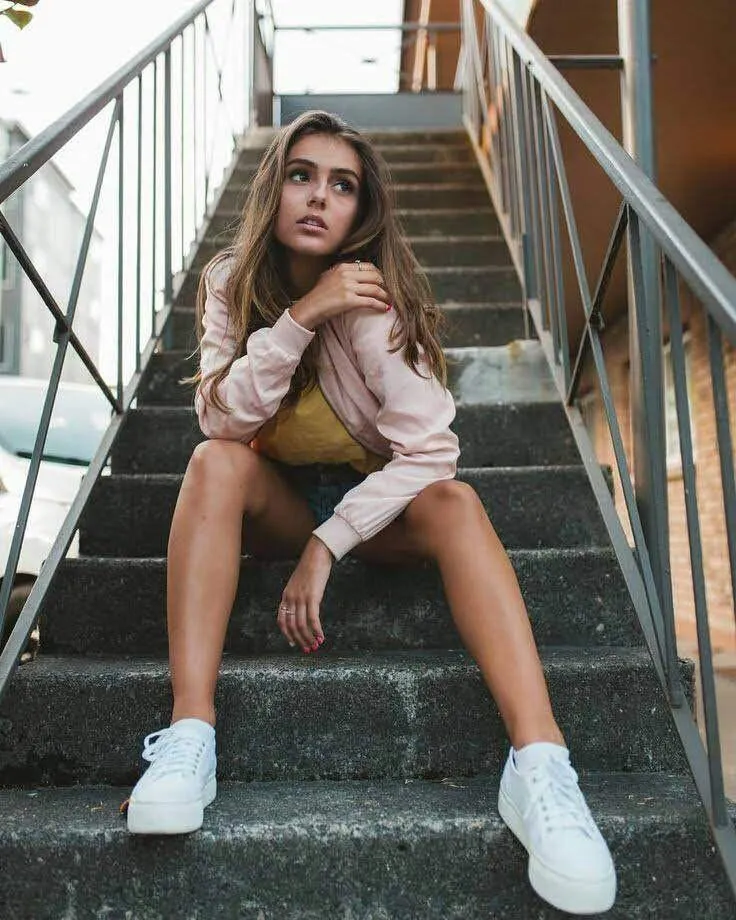 Woman Sitting on Stairs in a Casual Urban Outfit Wallpaper