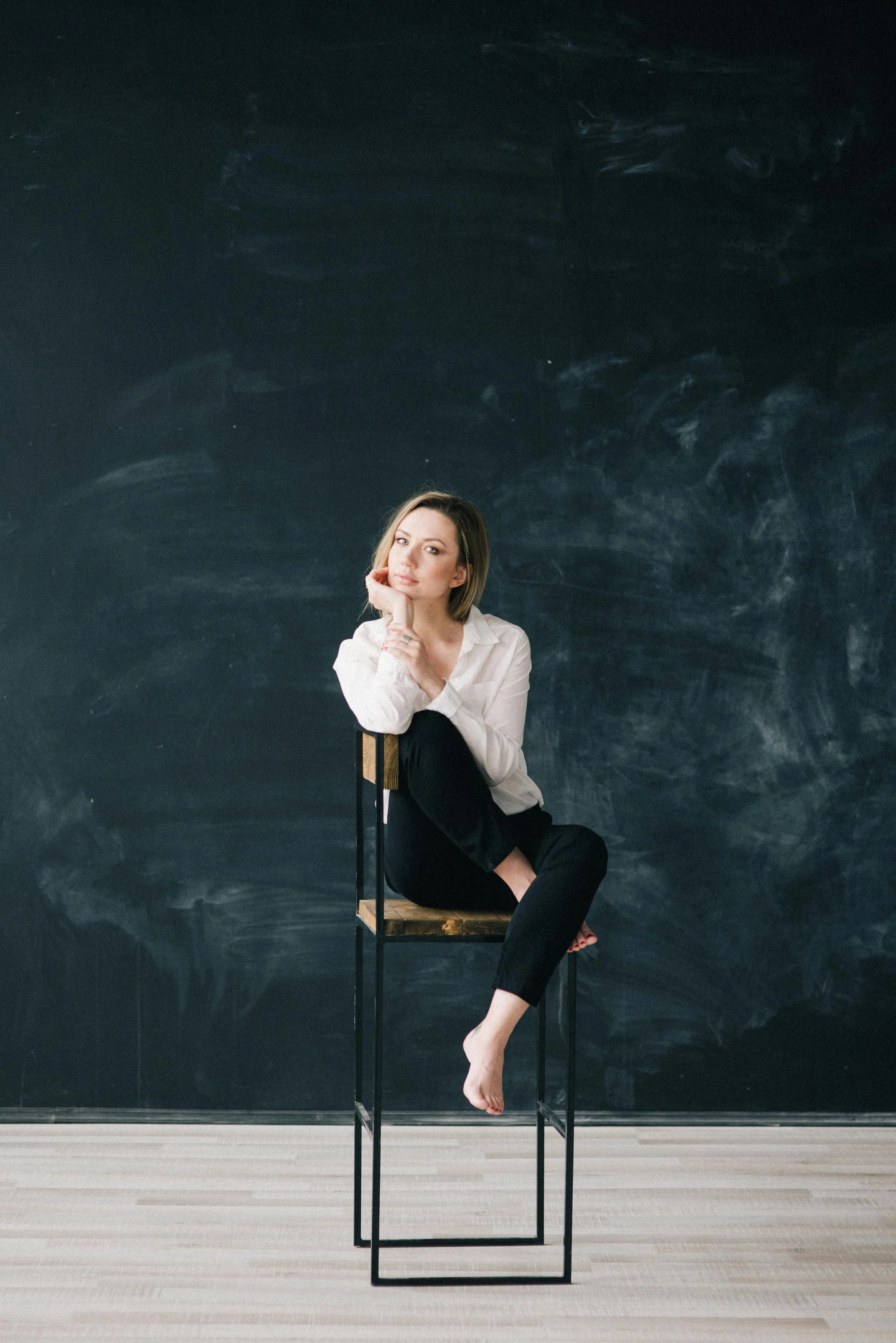 Woman Sitting on Stool in Front of Chalkboard Wall Wallpaper
