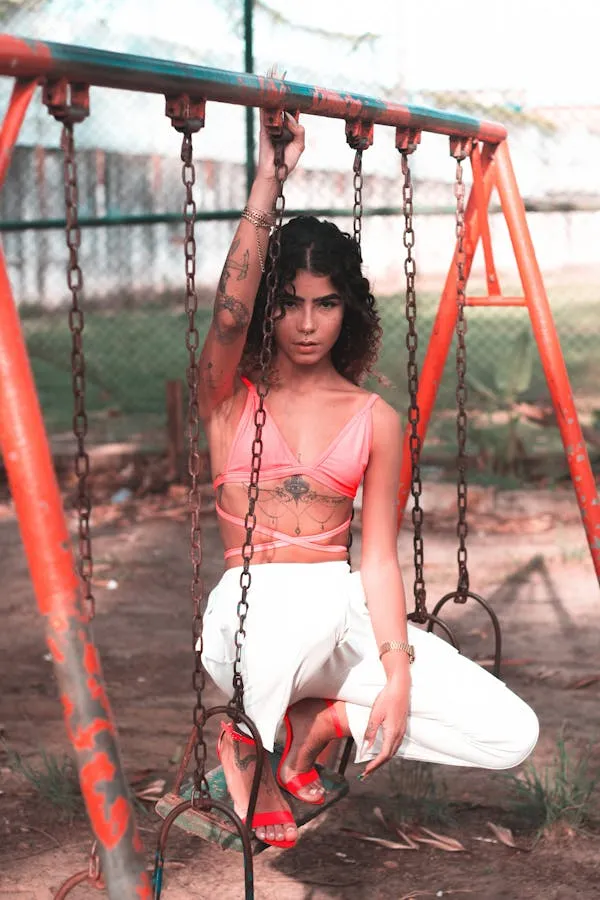 Woman Sitting on a Swing in a Casual Style At a Playground