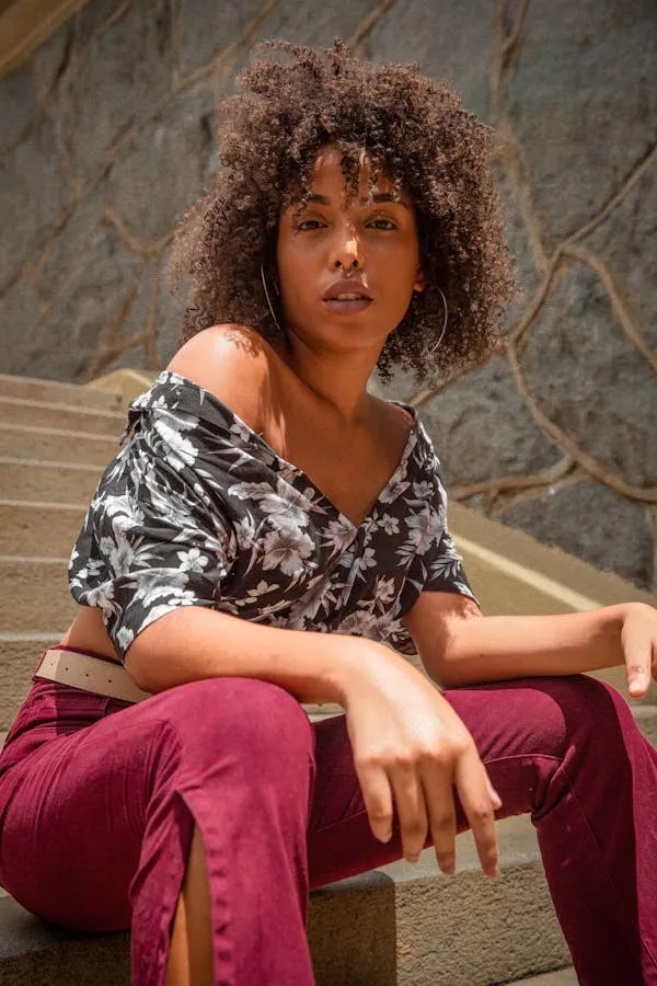 Woman Sitting on the Stairs Wearing Patterned Top and Pants
