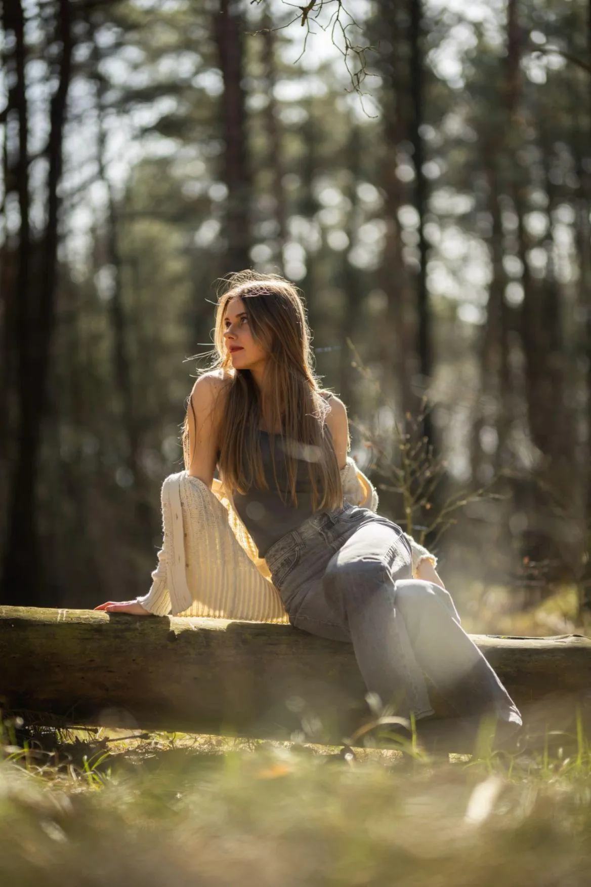 Woman Sitting on a Tree Log in a Quiet Forest Setting Image