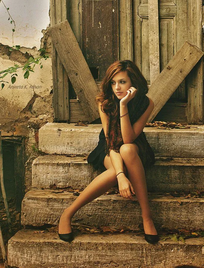 Woman Sitting on Wooden Steps with Relaxed Posture Wallpaper