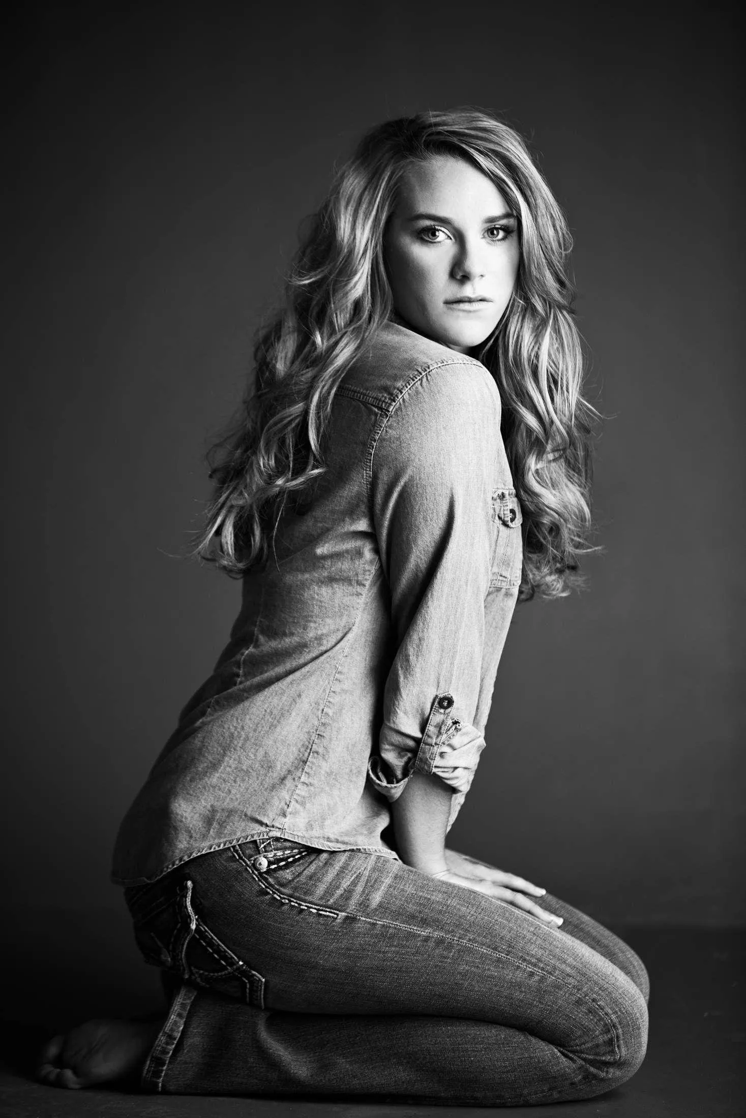 Woman Smiling by a Tennis Court Wearing a White Sweater