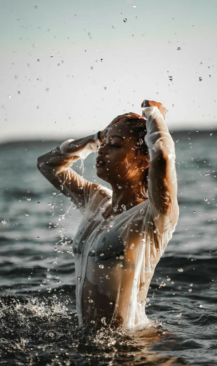 Woman Splashing Water Outdoors on a Sunny Day by the Sea