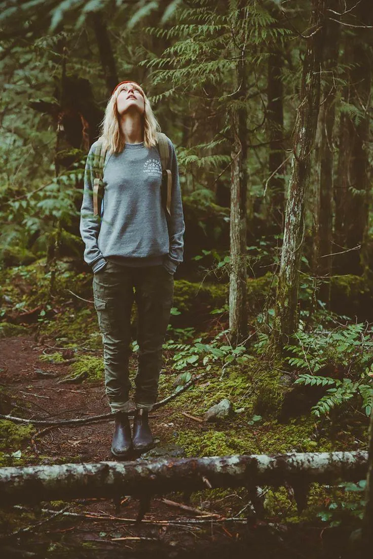 Woman Standing Alone in the Forest Looking Into the Trees