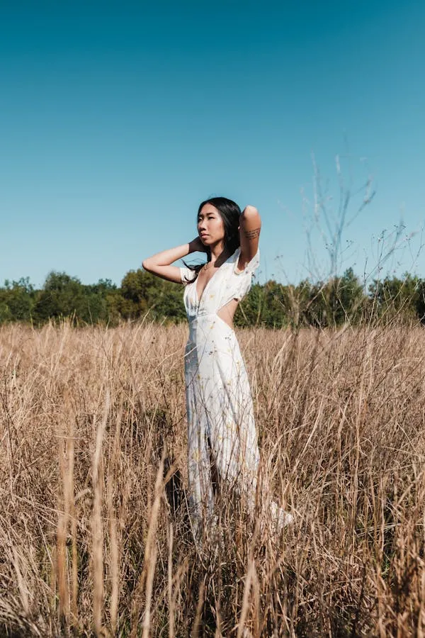 Woman Standing in a Field Wearing a Long White Dress Image