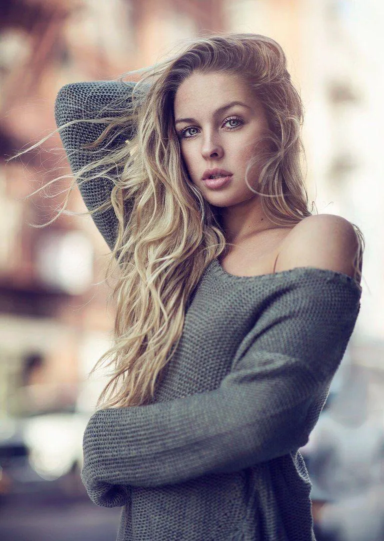 Woman Standing Near a Stone Wall in a Casual Modern Outfit