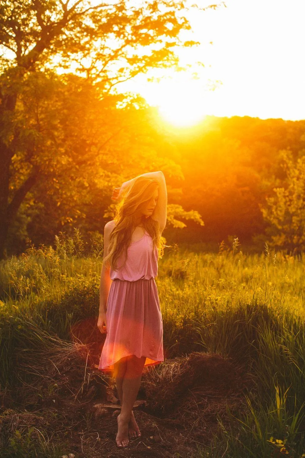 Woman Standing in a Sunlit Field At Golden Hour Sunset Image