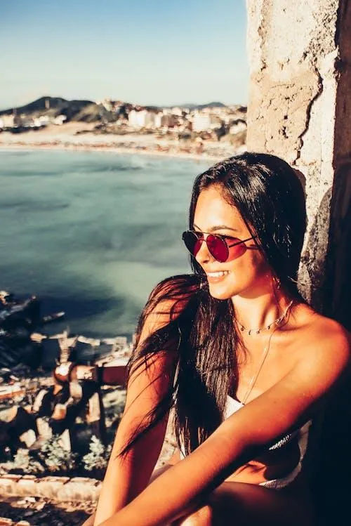 Woman with Sunglasses Enjoying Sunny Coastal Scenic Views