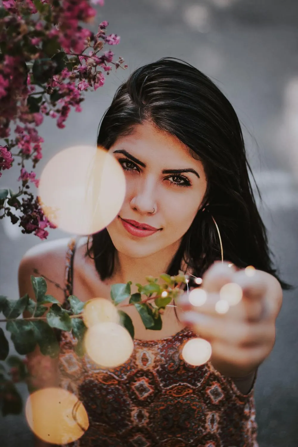 Woman Surrounded by Lights Posing with a Floral Background