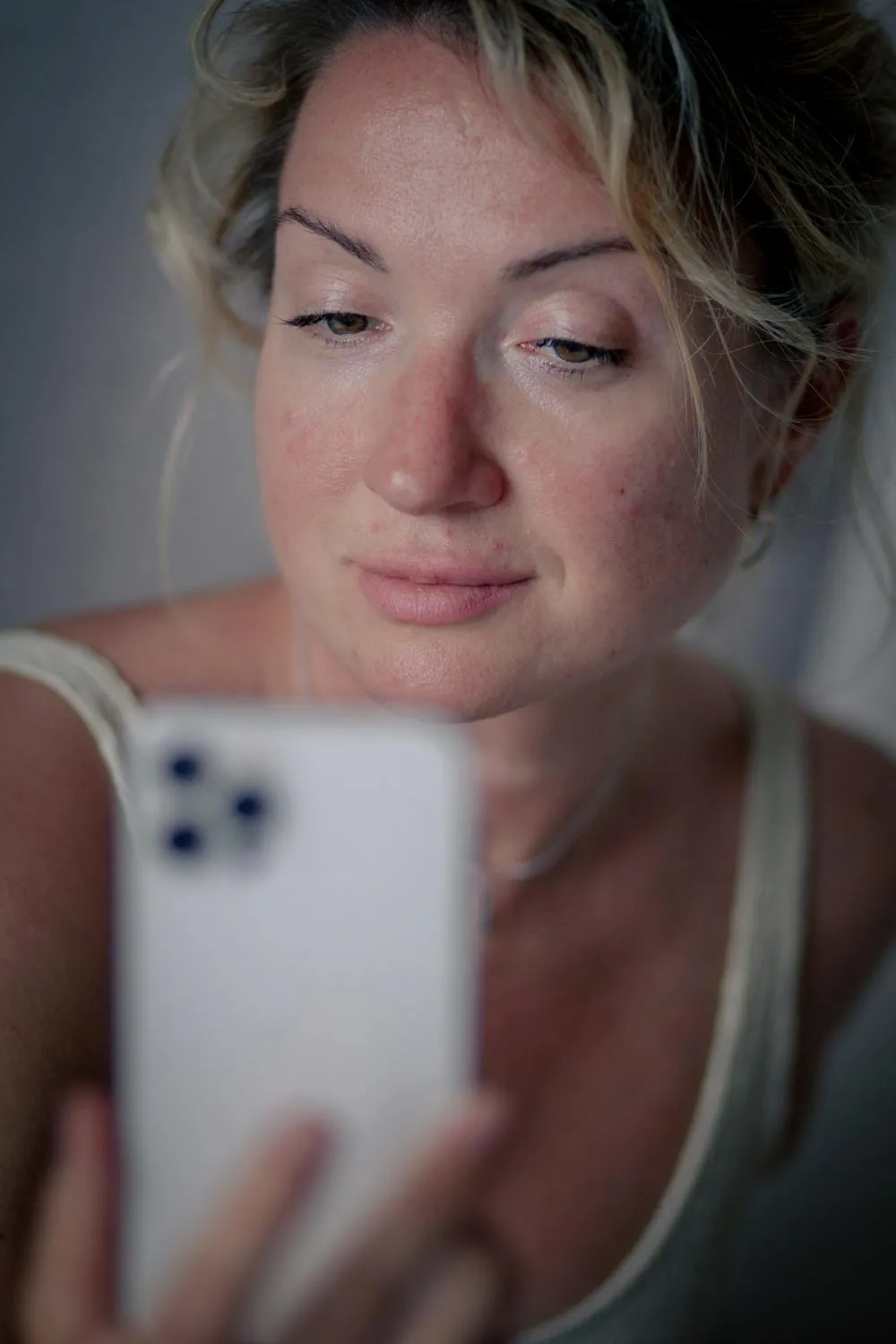 Woman Taking a Selfie with a Smartphone in Soft Lighting
