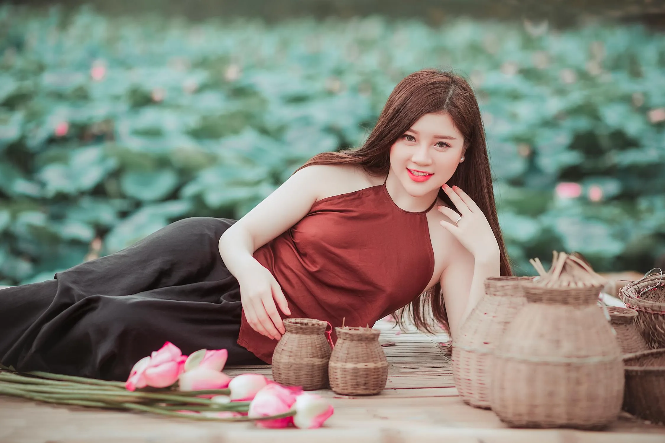 Woman in Traditional Dress Sitting Outdoors with Baskets