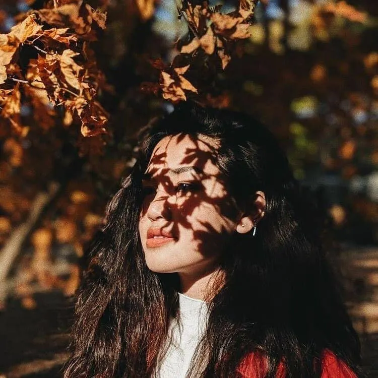 Woman Walking Through Autumn Forest with Tall Orange Trees