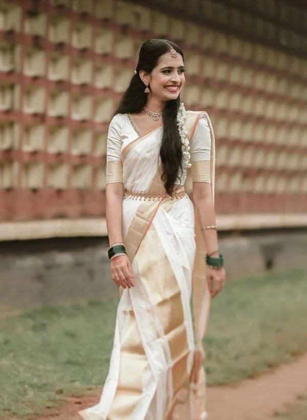 Woman walking with a smile wearing a Kasavu saree wallpaper