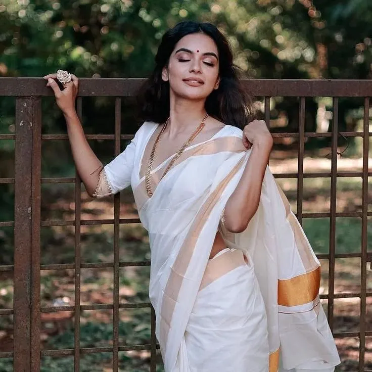 Woman wearing a Kerala Nerial Saree with eyes closed pose