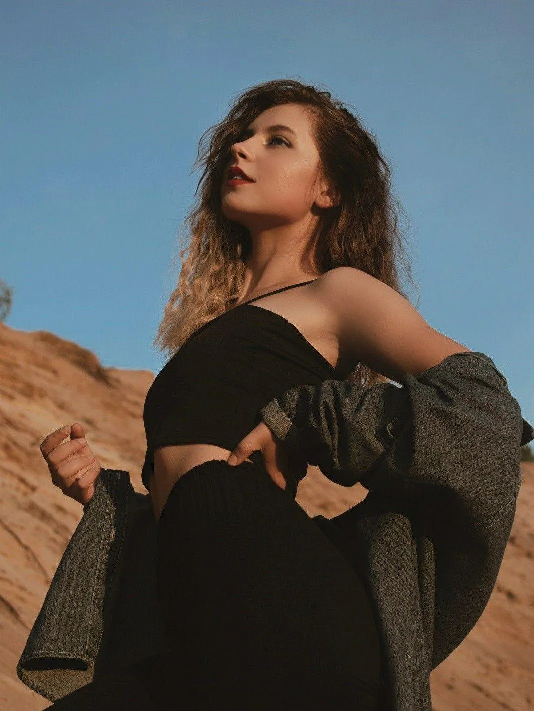 Woman Wearing Black Dress Posing Outdoors with Strong Stance