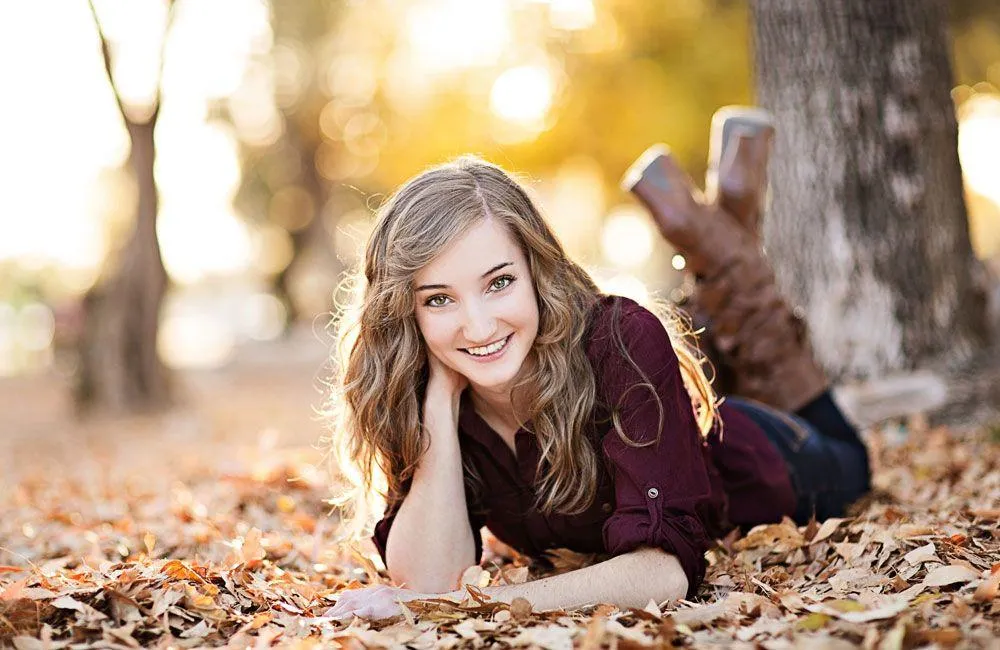 Woman in a White Dress Standing by Large Blooming Flowers