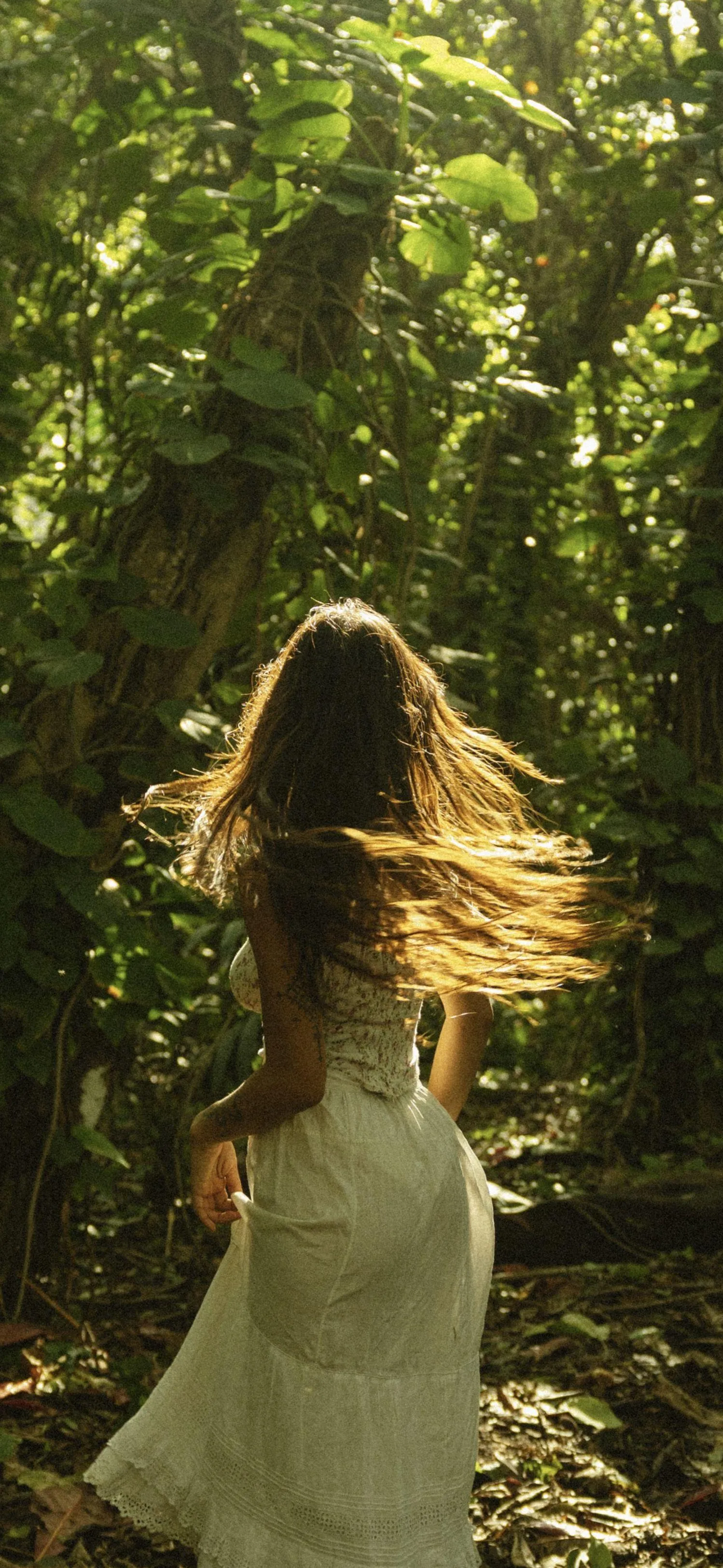 Woman in a White Dress Walking Peacefully Through the Forest