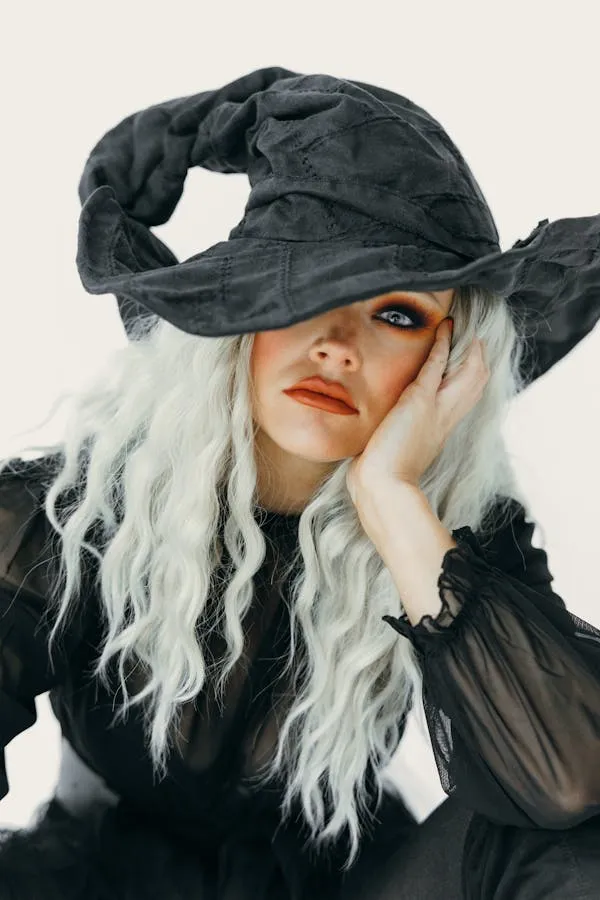 Woman with White Hair and a Black Hat Posing Thoughtfully