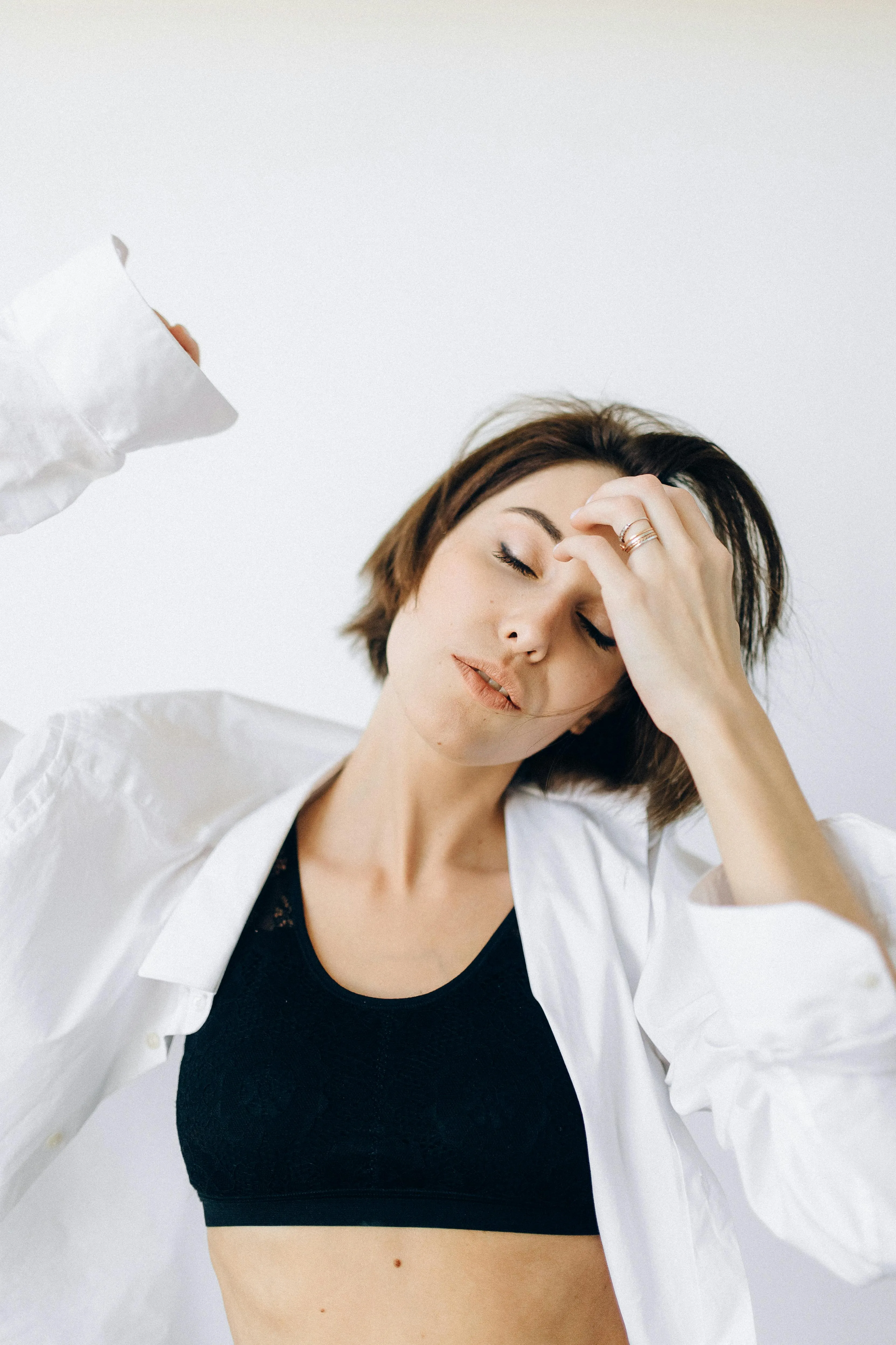 Woman in a White Shirt Stretching on the Bed in the Morning