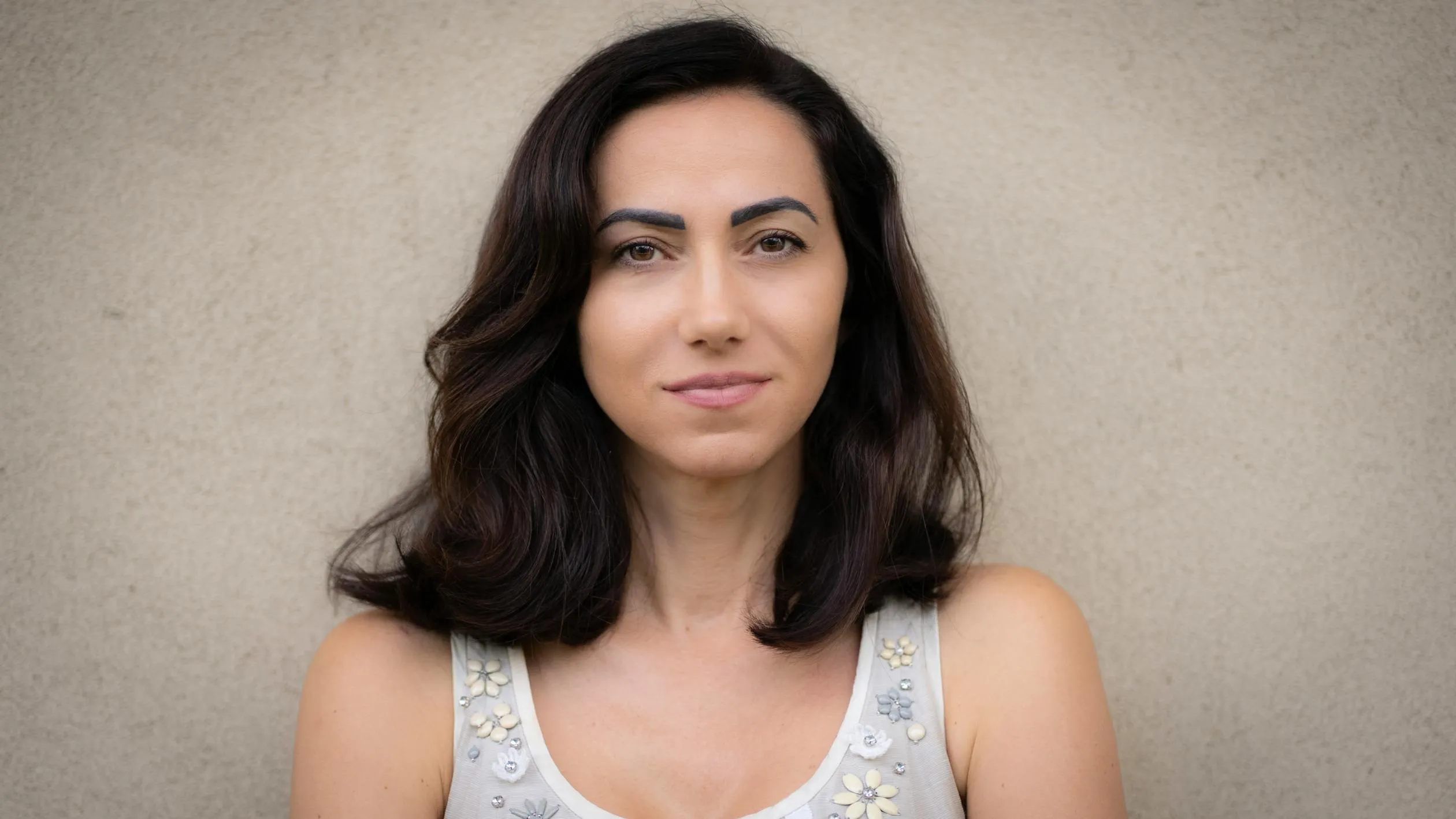 Woman in a White Tank Top with a Calm and Neutral Expression
